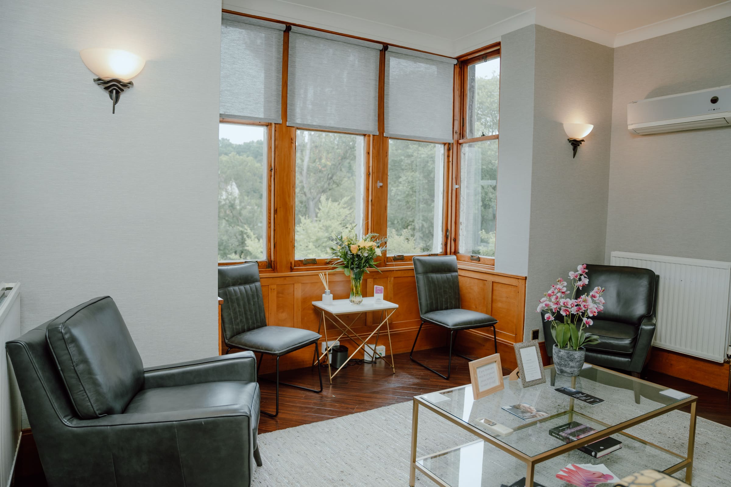 The patient lounge at Cherrybank Dental Spa, with armchairs and flowers by the bay window